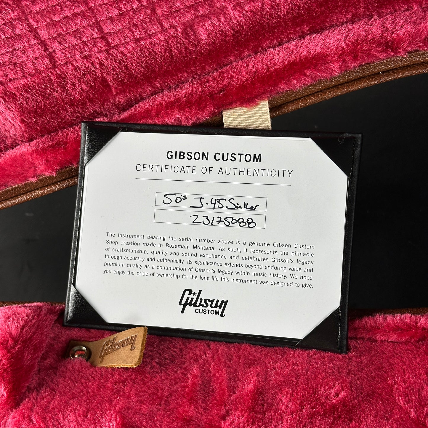 Gibson Custom Certificate of Authenticity on a red textured surface