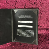 Gibson Custom Certificate of Authenticity on a textured red surface