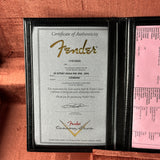 Fender certificate of authenticity with pink paper on a brown background