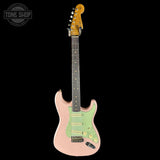 Electric guitar with a pink body and green pickguard on a white background