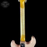 Close-up of a guitar neck with a pink body on a black background, featuring the Tone Shop logo.