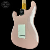 Pink electric guitar with a visible brand logo on a black background