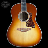A Taylor acoustic guitar with a classic sunburst finish, featuring a warm orange and brown gradient on a black background. The brand logo is visible on the headstock (partially cropped) and the fretboard, and a 'TONE SHOP' watermark is in the top-left corner.