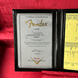 Fender certificate of authenticity in a black leather case on a red background