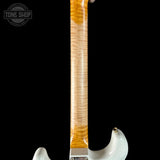 Guitar neck with a white pickguard on a black background, featuring the Tone Shop logo.