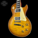 A classic electric guitar with a natural flamed maple top, cream pickguard, and gold hardware, photographed against a solid black background with a Tone Shop watermark in the top left corner.