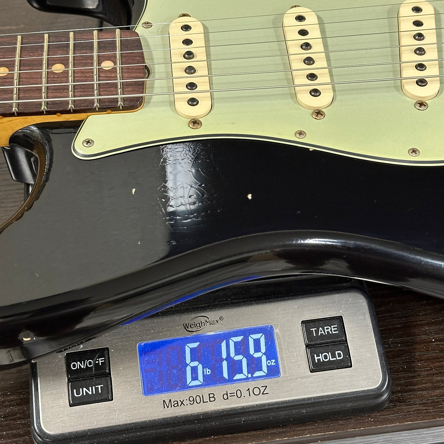 Guitar on a digital scale displaying weight