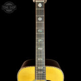 Close-up of the neck of an acoustic guitar with mother-of-pearl inlays on a black background, featuring a Tone Shop watermark in the top left corner.