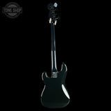 A black electric guitar shown from the back, featuring a glossy finish and a visible Tune Shop logo watermark in the top-left corner against a solid black background.
