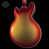 Close-up back view of an electric guitar body with a metallic gold and red gradient finish, shown against a black background with a Tone Shop watermark in the top left.