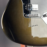 Close-up of a glossy metallic olive green electric guitar body with chrome hardware, including a bridge and pickups, on a dark gray background.