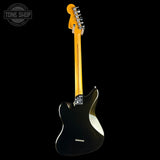 A black electric guitar shown from the back against a solid black background, featuring a bright yellow maple neck and headstock with chrome hardware. A Tone Shop watermark is visible in the top-left corner.