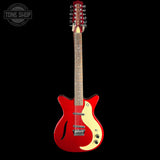 A red electric guitar with a cream pickguard and maple neck, shown against a solid black background. A Tone Shop watermark is visible in the top-left corner.