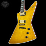 A yellow flamed maple electric guitar with black hardware and cream humbucker pickups, shown against a solid black background with a Tone Shop watermark in the top-left corner.
