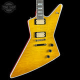 A yellow-finish electric guitar with a distinctive angular body, black hardware, and a red edge outline, shown against a black background with a Tone Shop watermark in the top-left corner.