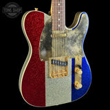 A custom electric guitar with a red, silver, and blue glitter body design, featuring a gold-toned pickguard and hardware, shown against a black background.