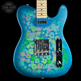 A blue electric guitar with a vibrant green, pink, and light blue retro floral pattern, shown against a solid black background with a Tone Shop watermark in the top-left corner.