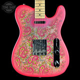 A pink electric guitar with a vibrant paisley and floral pattern in pink, green, and gold over a glossy finish, shown against a solid black background with a Tone Shop watermark in the top left corner.