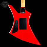 The rear view of a red electric guitar with a unique angular body, black pickups, and a light wood neck, shown against a solid black background.