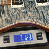 Close-up of a guitar body resting on a digital scale displaying 7.123 lbs, with the scale showing brand Weightworks.