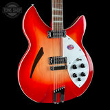 A double-cutaway electric guitar with a red-to-orange sunburst finish, featuring a white pickguard, black hardware, and a maple neck, shown against a solid black background.