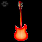 The back view of an electric guitar with a vibrant red-to-orange sunburst finish, shown against a solid black background with a Tone Shop watermark in the top left corner.