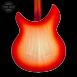 Close-up of the back of an electric guitar showing a classic sunburst finish that transitions from a bright red edge to a warm amber-orange center, with a light natural wood grain in the middle. The neck is visible at the top against a solid black background.