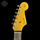 Close-up of a Fender guitar headstock with 'Tone Shop' logo in the corner.