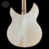 The back of an electric guitar body made of natural, unfinished maple wood, showing a prominent flame grain pattern, set against a solid black background with a Tone Shop watermark in the top left corner.