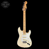 A classic Fender Stratocaster electric guitar with a cream-colored body, maple neck, and gold hardware, shown against a solid black background with a Tone Shop watermark in the top-left corner.