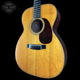 Acoustic guitar with a visible brand logo on a black background
