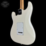 The rear view of a Fender Stratocaster electric guitar in a glossy off-white/cream finish, featuring a white pickguard and a natural wood neck against a solid black background.
