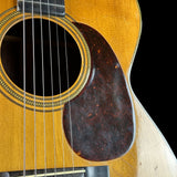 Close-up of an acoustic guitar's soundhole and wooden body on a black background
