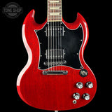 A red electric guitar with a black pickguard and chrome hardware, shown against a black background with a Tone Shop watermark in the top left corner.