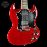 A red electric guitar with a black pickguard and chrome hardware, shown against a solid black background. A circular 'TONE SHOP' watermark is visible in the top-left corner.