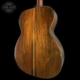 Close-up of a wooden acoustic guitar body with 'Tone Shop' logo in the corner.