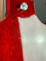 Close-up detail of a glossy red wood grain surface with a visible silver screw fastener and a bright reflection.