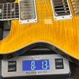 Yellow electric guitar on a digital scale displaying weight.