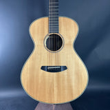 Acoustic guitar with a natural wood finish on a dark blue background