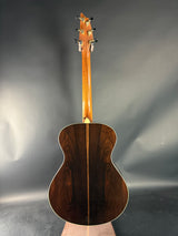 Wooden acoustic guitar on a reflective gray surface