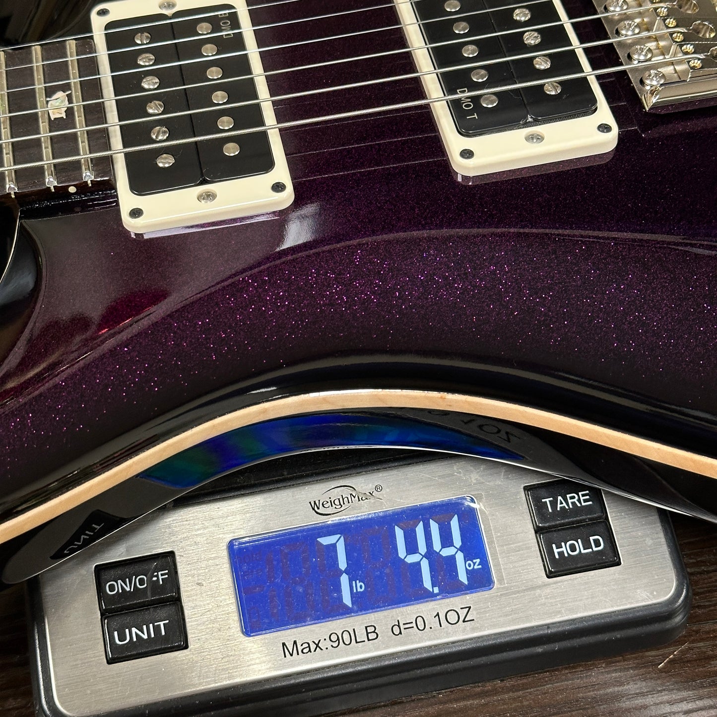 Guitar on a digital scale displaying weight measurement