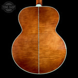 The back of an acoustic guitar with a glossy flamed maple top, showing a warm brown wood grain and a white binding edge, set against a solid black background with a Tone Shop logo in the top left corner.