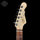 Close-up of an electric guitar headstock with a natural maple wood finish, featuring six black tuning pegs and a dark brown fretboard, shown against a solid black background.