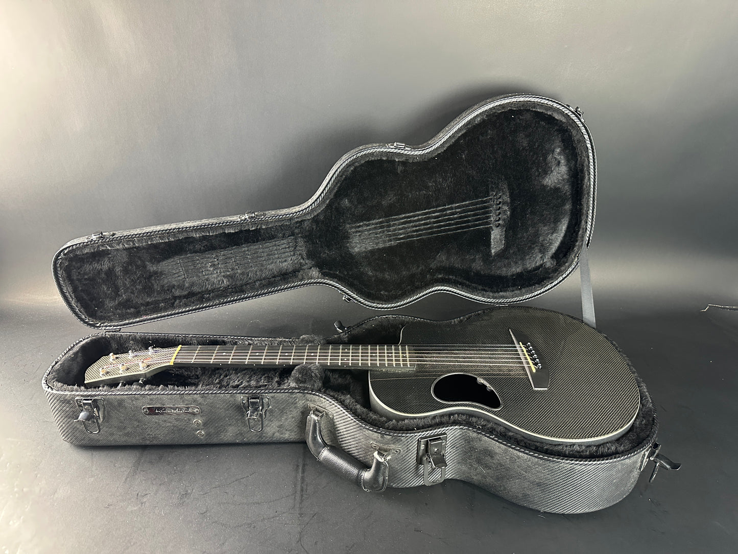 Acoustic guitar in an open case on a gray background
