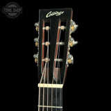 Close-up of the headstock of a Collings acoustic guitar against a black background, showing the brand name in white script, six tuning pegs, and part of the dark fretboard.