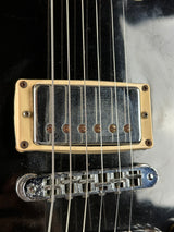 Close-up of a guitar's pickup and bridge on a black background
