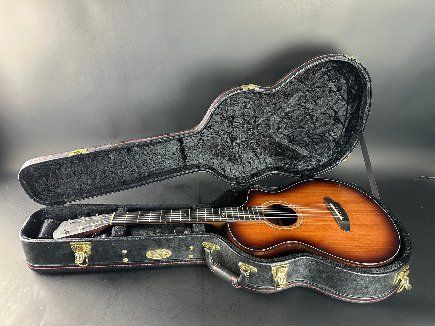 Acoustic guitar in a hard-shell case on a gray background