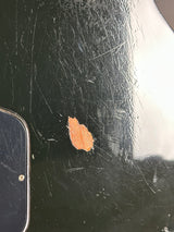 Scratched black surface with a small brown patch