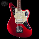 A red electric guitar with a cream pearlescent pickguard and black control plates, shown against a black background with a Tone Shop watermark in the top left corner.