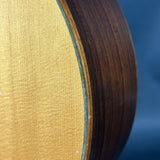 Close-up of a guitar's soundhole and wood finish with a blue background